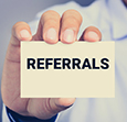 REFERRALS word on business card shown by a man, vintage tone